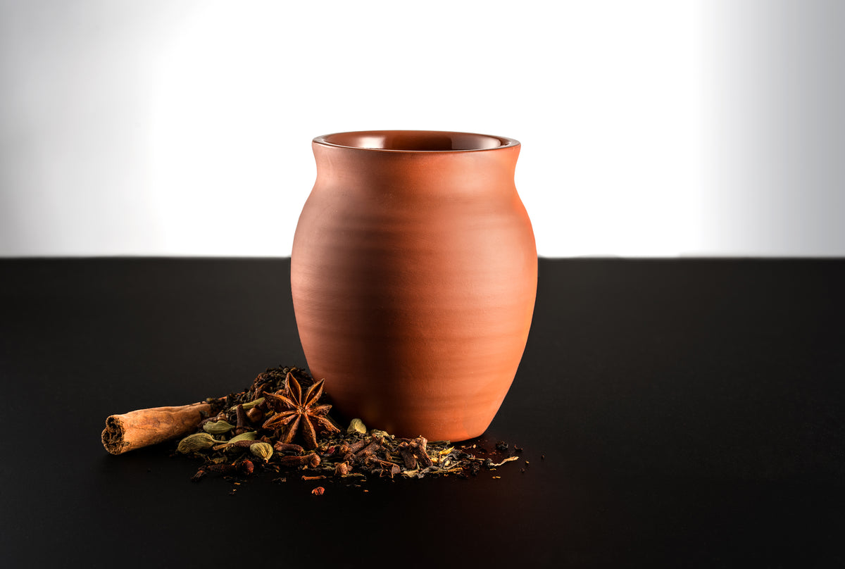A matte finish Jalisco jug on a black countertop and white background. Surrounded by spices consisting of cinnamon sticks, star anise, and other spices.