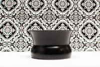 Volcanic ash (black) Oaxaca glass on white counter with an arabesque pattern tile in the background